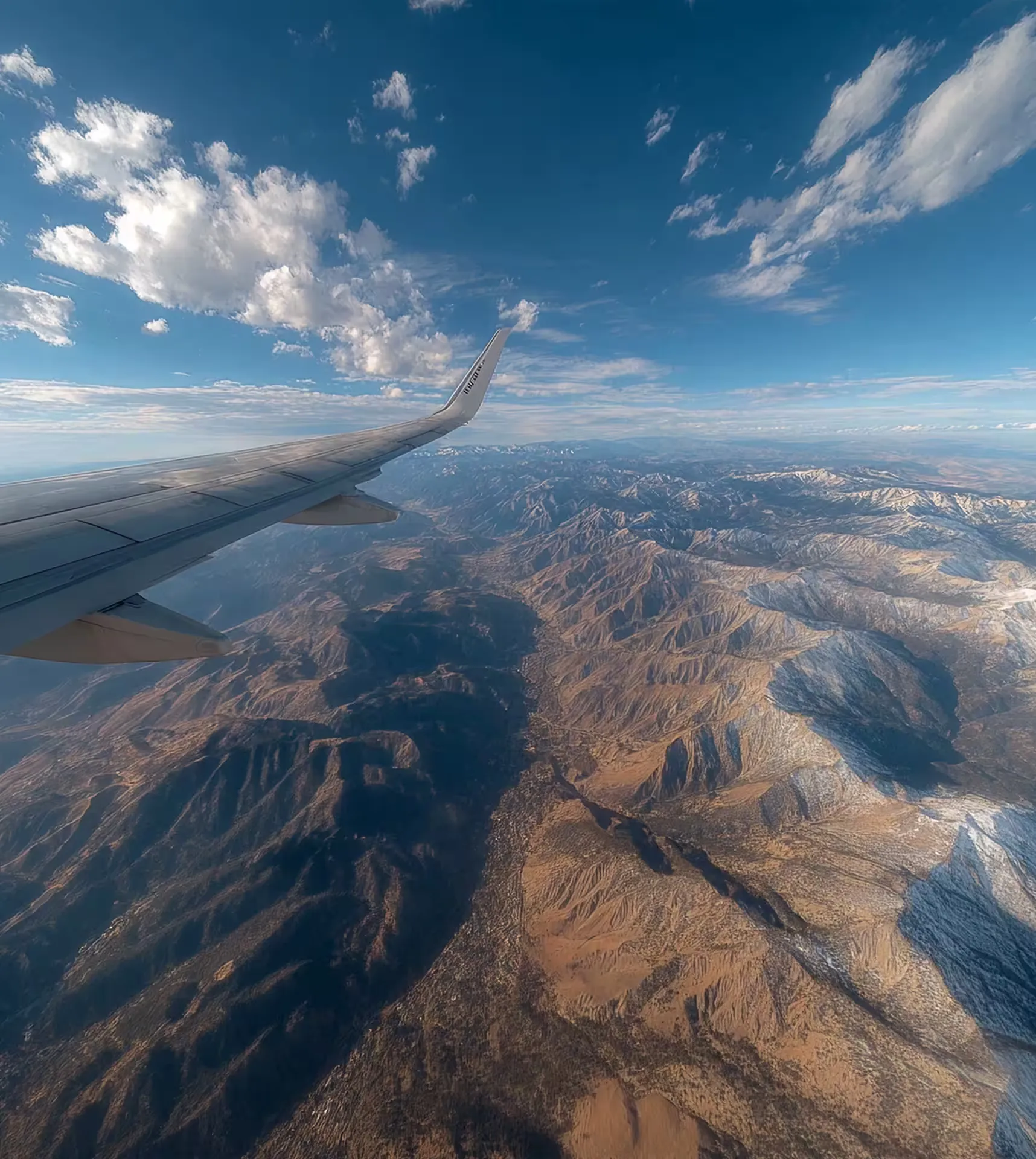 View from an aircraft wing over a mountain range